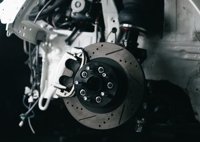 Detailed view of a vehicle's disc brake system with caliper, showcasing automotive technology.